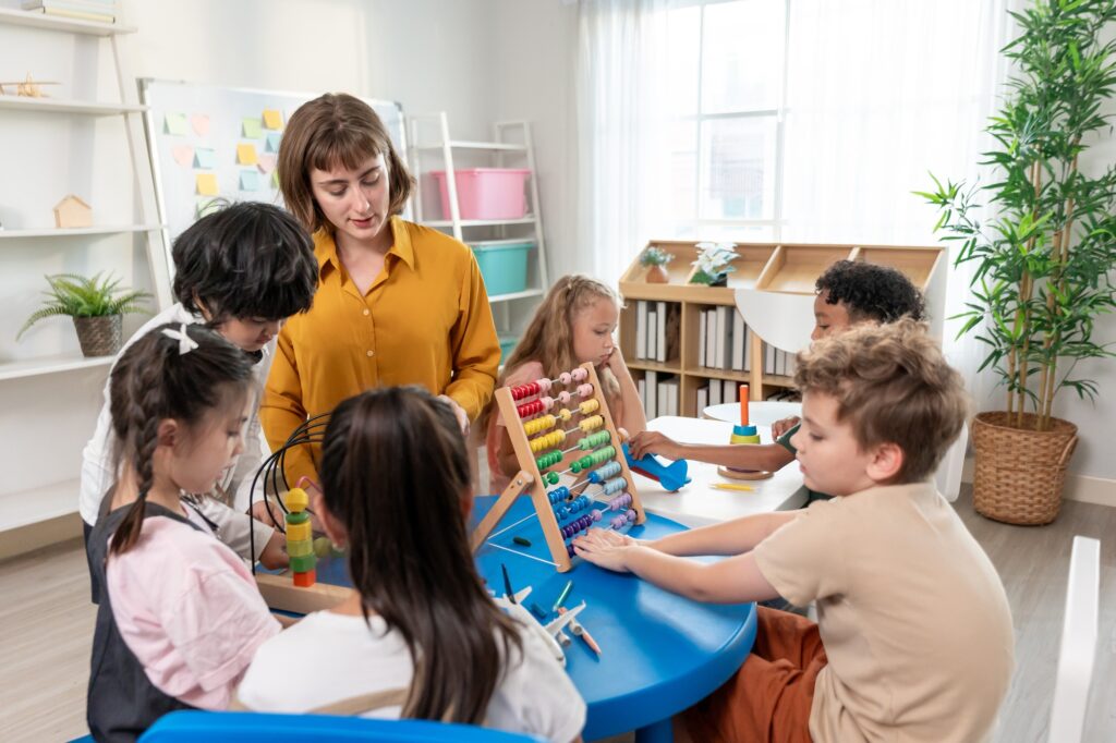 Adorable young children student playing education toys in nursery school.