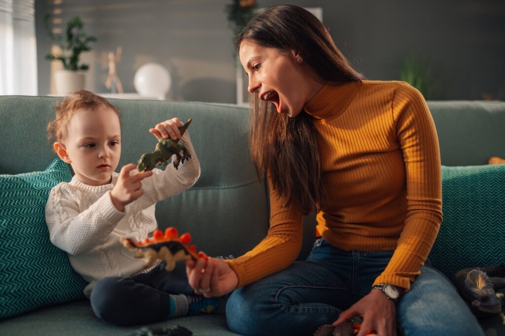 Baby sitter and child boy spending time at home and playing with toys