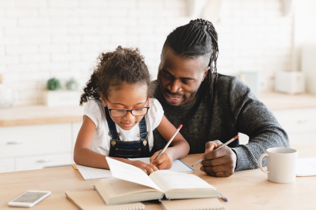 Dad tutor childminder helping assisting with homework school project to a preteen daughter student