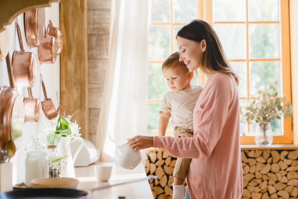 Morning home breakfast. Motherhood. Adoption. Nanny childminder babysitter holding toddler newborn